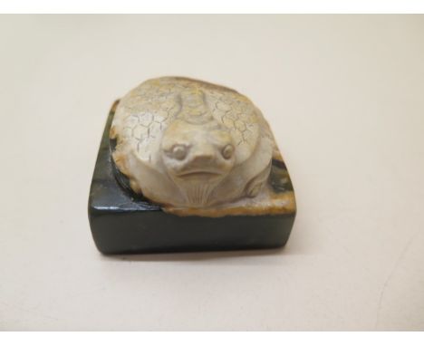 A carved jade turtle on a square base, 3.5cm tall x 5cm x 5cm, signed to base, large chip to one corner otherwise generally g