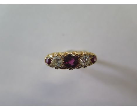A ruby and diamond modern 'boat' ring in yellow colour metal, graduated size stones comprising of a central circular faceted 