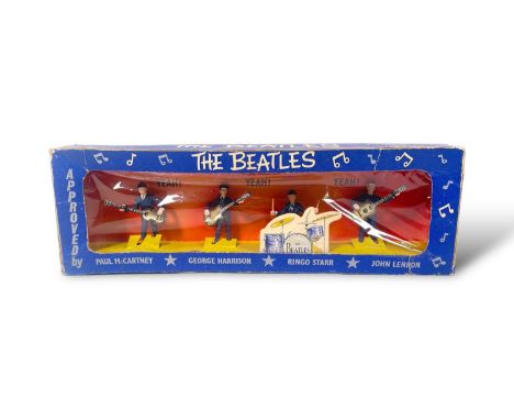 An original set of four Beatles figurines by Subbuteo, in original cardboard box. Shows wear and tape. Figures appear in exce