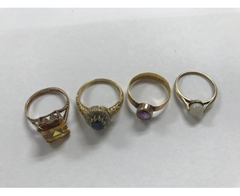 A 22 ct gold ring inset with amethyst and three other 9 ct gold rings .