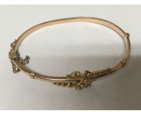 A 9carat gold bangle with raised decoration. Weight 4.5g