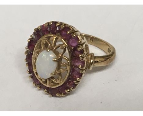 A 9carat gold ring set with a central Opal with an open design flanked by ruby. Ring size K.