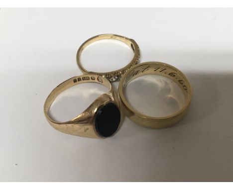 A 9ct gold ring set with onyx a gold wedding band and one other ring set with CZ. 7.5g