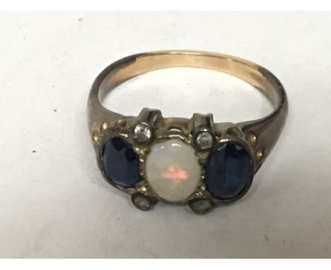 An unmarked ring set with blue sapphire and Opal with four small corner diamonds ring size N.