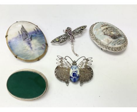 A silver dragonfly brooch, a silver jade brooch and three others.