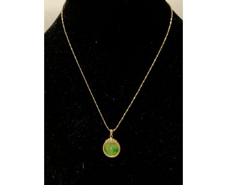 A jade and diamond set 18ct gold pendant on an 18ct gold chain.