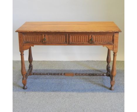 A Victorian light oak two drawer side table, on turned legs, united by a bobbin turned stretcher, 124cm