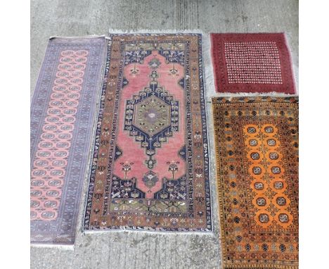 A Persian rug, with a central medallion, on a pink field, 252 x 127cm, together with a Bokhara runner on a pink ground, anoth