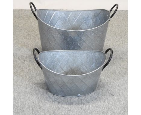 A large oval metal planter, 62cm, together with another smaller