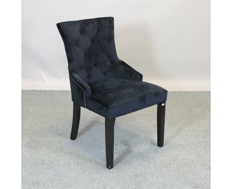 A black upholstered button back bedroom chair