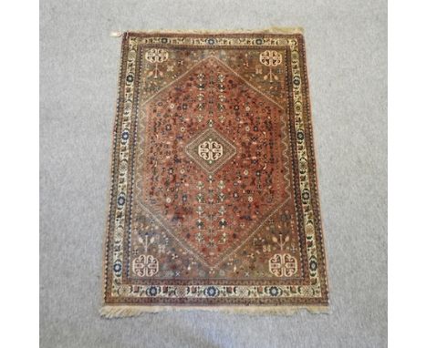 A Persian woollen rug, with a central medallion and flowers, birds and animals, on a red ground, 160 x 110cm