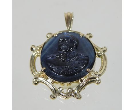 An unmarked sapphire pendant, carved with a cameo portrait bust of a military figure, with a scrolled surround, 3.5cm wide 