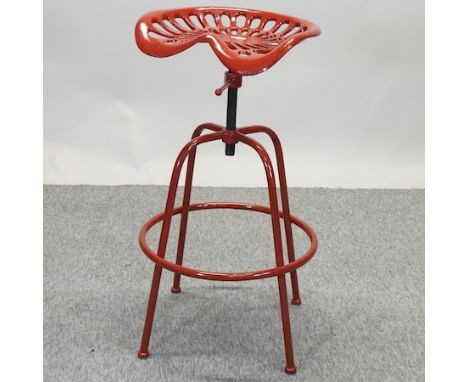 A red painted cast iron tractor seat bar stool