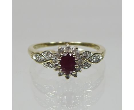 A 9 carat gold ruby and diamond cluster ring, with diamond set shoulders