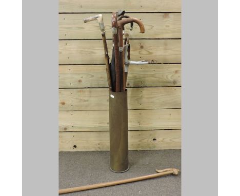 A collection of walking sticks, together with an umbrella and shooting stick
