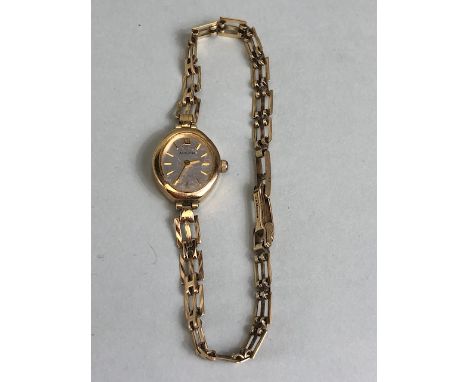 9ct Gold Oval faced watch with silver face and baton numerals on a 9ct gold gate-link bracelet strap (total weight approx 9.5