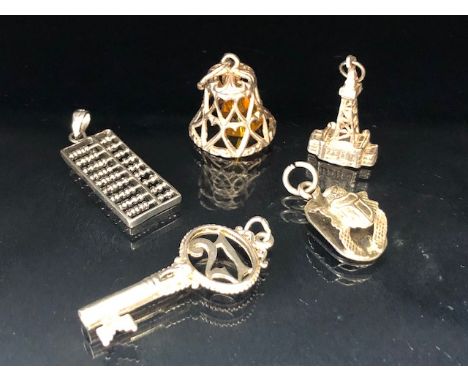 Collection of five charms to include an abacus, bell, key etc