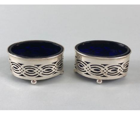 Pair of Silver salts with blue glass liners on four ball feet with pierced decoration Hallmarked for Birmingham maker  Willia