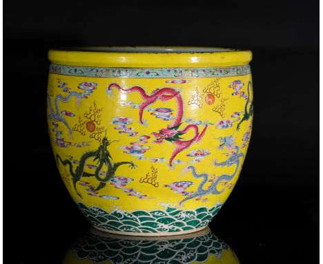 Chinese Art. A porcelain fish bowl decorated with dragons chasing the flaming pearl over yellow ground and bearing a six char