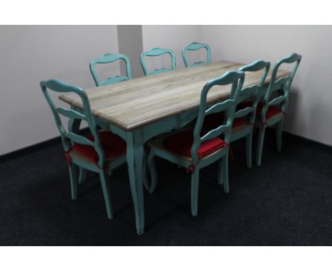 A French farmhouse kitchen table on painted base together with a set of seven painted ladder backed chairs 