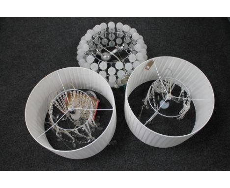 A contemporary chrome metal pendant light fitting with glass balls and two further light fittings with glass drops 