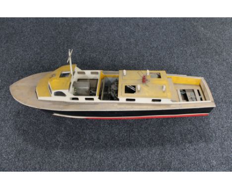 A hand built wooden boat with engine on stand 