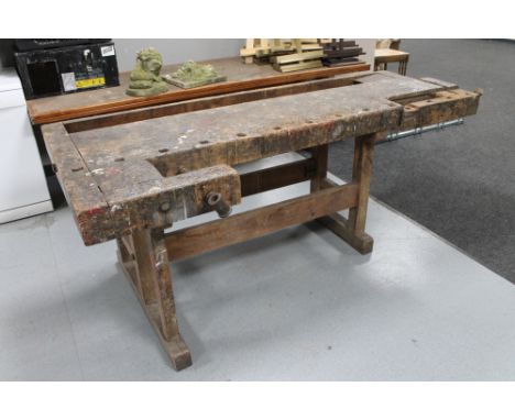 An early 20th century wooden work bench with two wooden vices 
