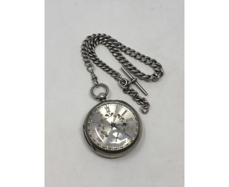 A large antique silver pocket watch with silver dial on heavy antique silver Albert chain