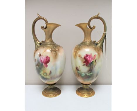 A pair of Royal Worcester gilded ewers hand-painted by R.H. Austin, height 25cm CONDITION REPORT: In good condition with no a