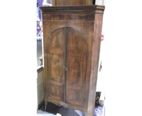 A George III crossbanded and line inlaid mahogany standing corner cabinet with Greek key pediment over two arched doors on sh