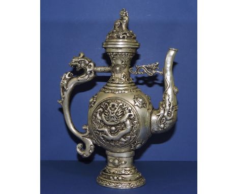 A Chinese white metal teapot, cast with dragons and dogs of Fo, with character mark to base, H. 23cm. 