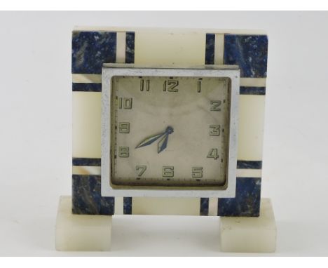 An Art Deco white onyx timepiece inlaid with lapis lazuli and mother of pearl bands, H. 12cm.