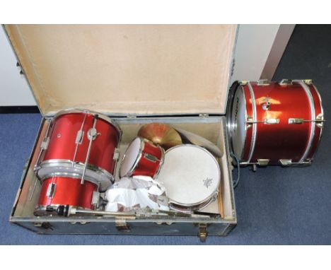 A child's Dragon drum kit, finished in candy apple red, within a zinc trunk.