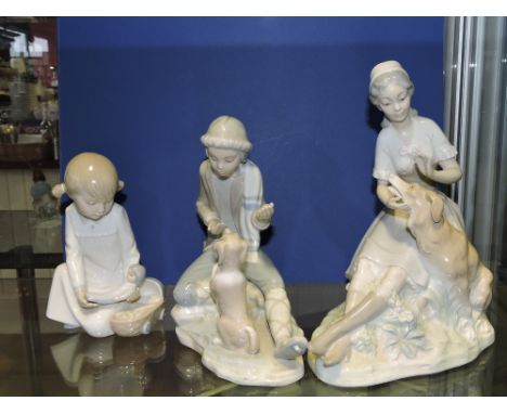 A Nao porcelain figure, seated girl with alsation, H. 23cm, a smaller Nao figure and one other.