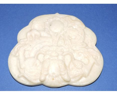 A Chinese white hardstone pendant of shaped square form carved with dragon and pearl motif. L. 8cm.