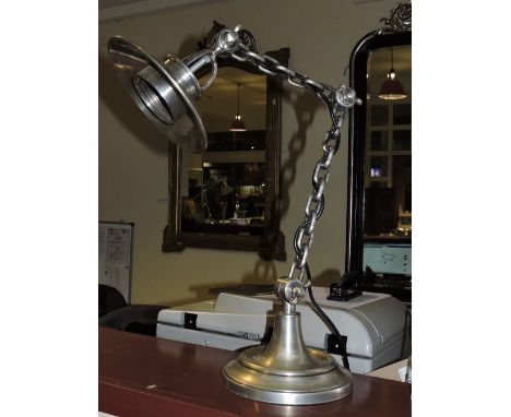 A plated metal adjustable desk lamp with chain link effect arm.