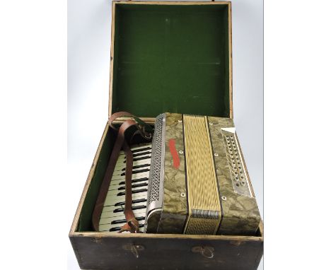 A Soberano piano accordion, with a brown marbled finish, contained within a wooden box.