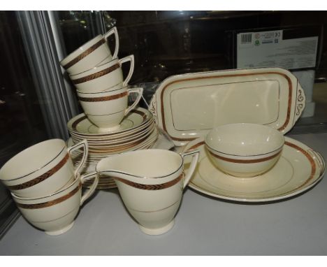 A Wedgwood lucerne pattern tea service, decorated with gilt bands on a cream ground.