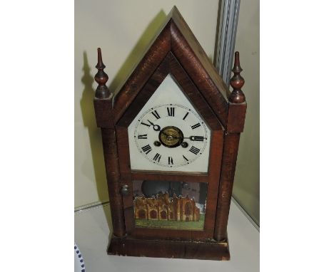 A late 19th Century American mahogany lancet mantel alarm clock, the door reverse painted with a view of Melrose Abbey, H. 39