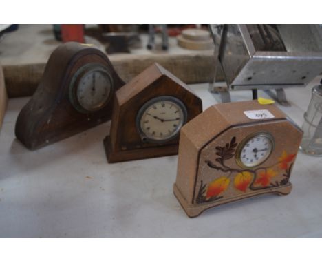 An Art Deco pottery mantel clock with brightly coloured floral decoration, an oak cased eight day clock and a Smiths mantel t
