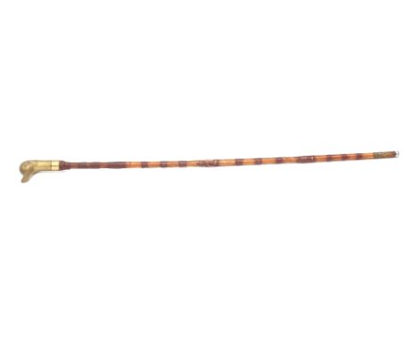 A cane walking stick with brass duckhead handle