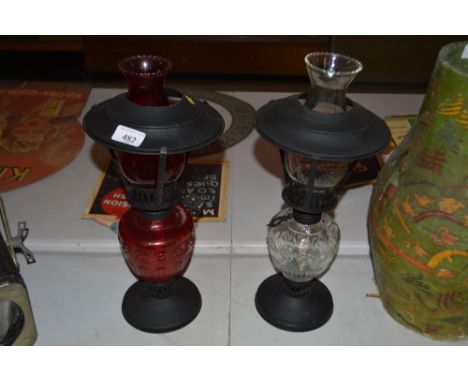 One ruby and one clear glass oil lamp