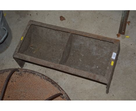 A cast iron two section pig trough AF