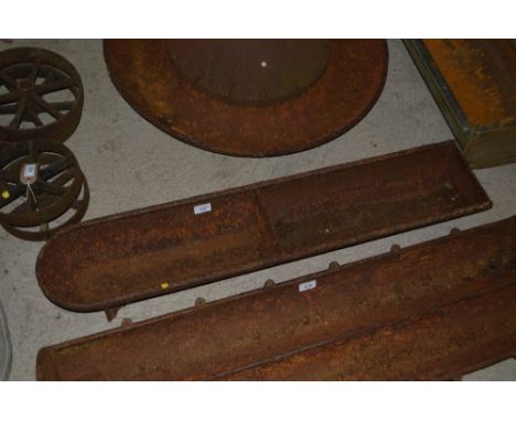 A cast iron two section pig trough 
