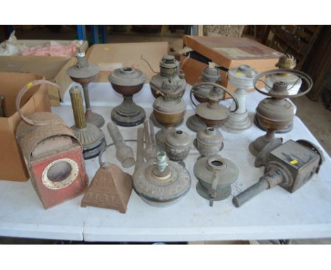 A large quantity of oil lamp bases, an old carriage lamp, oil lamp parts etc.