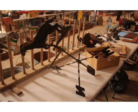 A metal weather vane with horse decoration