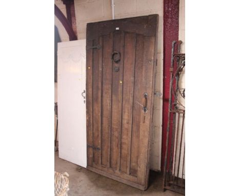 An old oak door with iron hinges, knocker and latch, 78ins x 37ins