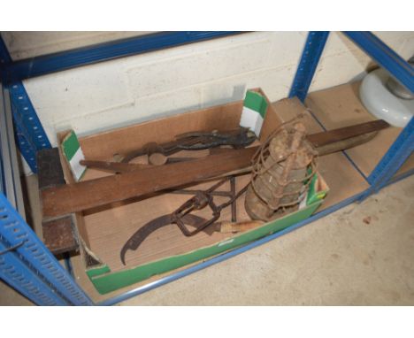 A box of various tools including a long handled saw, hurricane lamp etc.