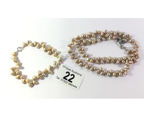 A pale pink pearl necklace and matching bracelet set in silver