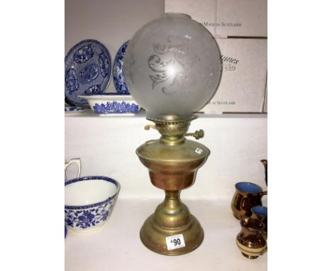 A brass oil lamp with etched shade (missing chimney)